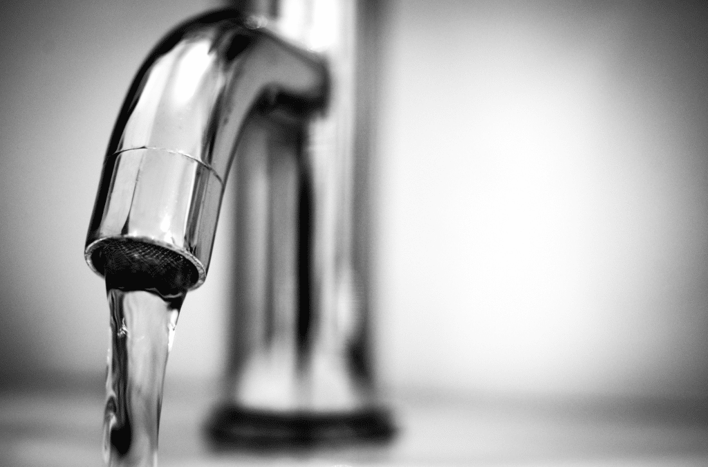 Close-up of a chrome tap with water flowing, symbolising clean and efficient plumbing solutions